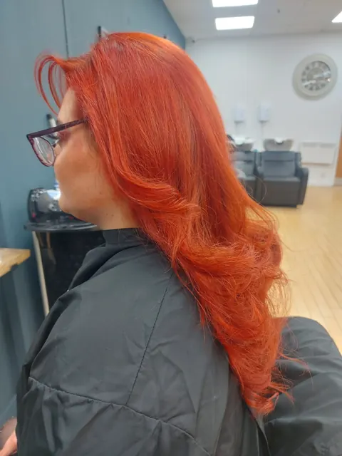 Copper red hair styled in soft waves, side profile